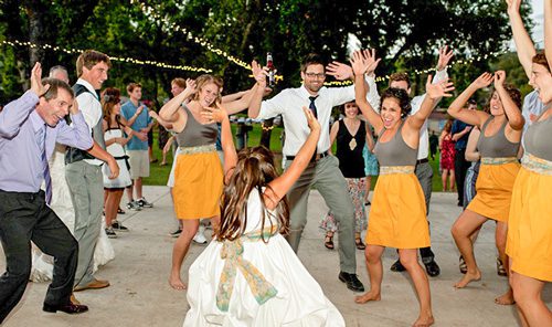 Why Choose Us? - Guests dancing at a wedding reception.